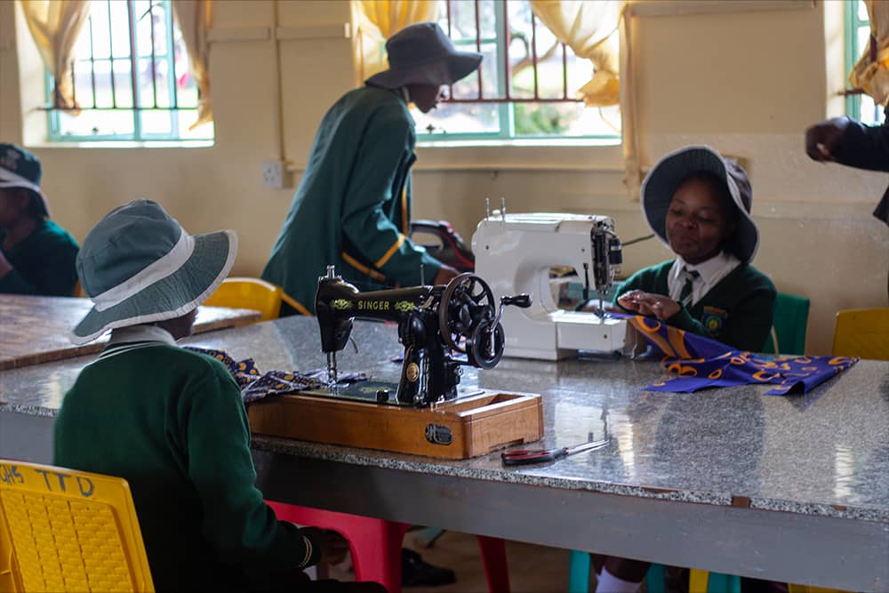 Students learning fashion design and sewing with modern equipment